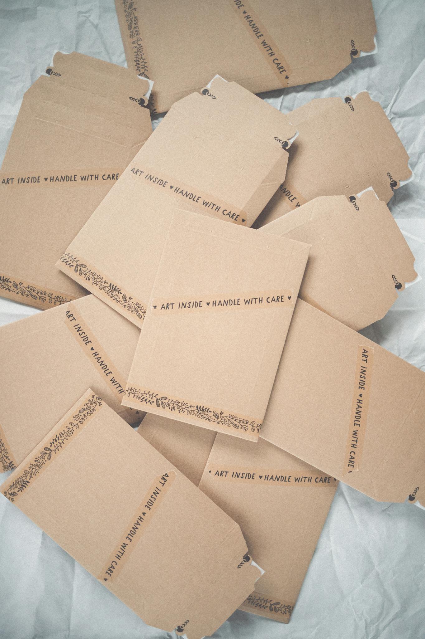 Artistic minimalist photo of cardboard packaging with 'Handle with Care' labels.